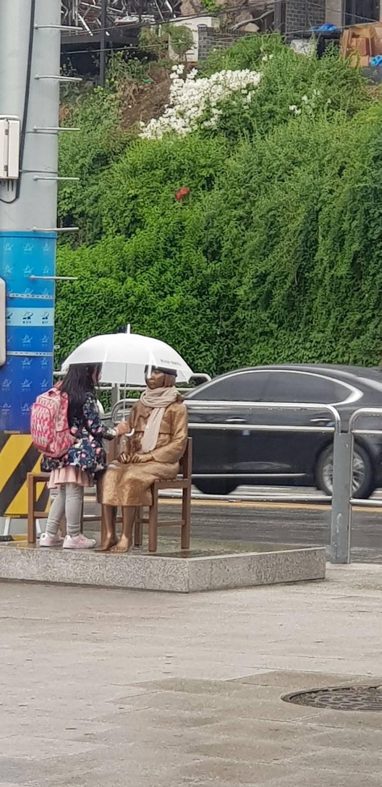 소녀상에 우산 씌워주는 어린아이 | 인스티즈