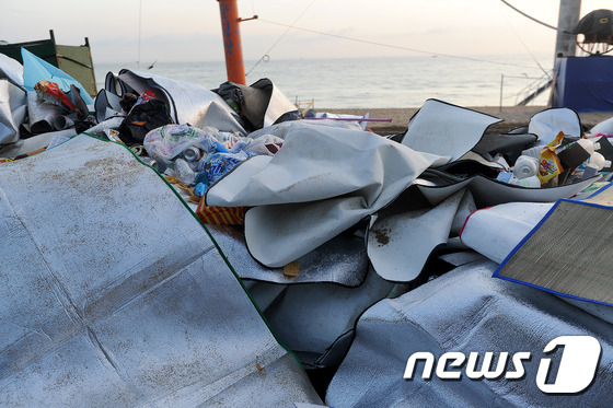 본격적인 여름휴가 시즌인 9일 강원 강릉 경포해변 곳곳에 버려진 술병과 각종 쓰레기들이 지난 밤의 흔적을 그대로 담고 있다. 강릉시 관계자에 따르면 이날 하루동안 배출된 쓰레기는 15t에 달한다. 2015.8.9/뉴스1 © News1 윤창완 기자