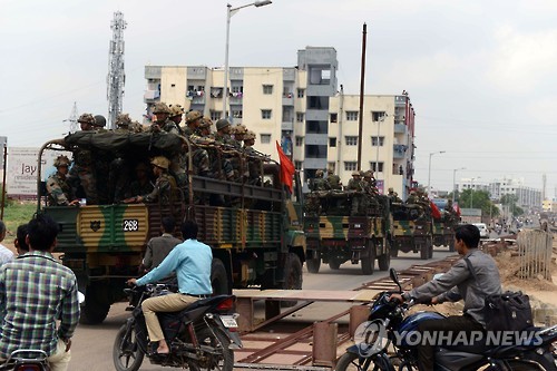 27일 인도 구자라트 주 아메다바드에서 하층민 우대정책에 반발한 파티다르 계층의 시위로 인한 소요사태를 막고자 파견된 군인들이 이동하고 있다.(AFP=연합뉴스)