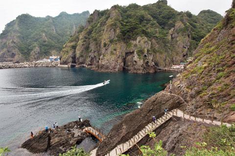 [월간산]바다를 시원하게 가르는 배와 해안절벽이 어우러진 산책로 풍광. 오른쪽에 있는 건물이 해안 식당 ‘용궁’이다.