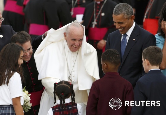 22일(현지시간) 미국 앤드루스 공군기지에 도착한 프란치스코 교황이 바람에 옷이 뒤집히는 가운데도 어린이들에게 미소로 인사하고 있다.© 로이터=뉴스1