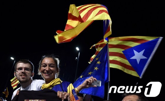 스페인 바르셀로나에 모인 카탈루냐 분리독립 지지자들이 27일(현지시간) 치러진 주의회 선거에서 분리독립을 지지하는 정당들이 과반 의석을 차지하자 카탈루냐 기를 흔들며 미소짓고 있다.© AFP=뉴스1 © News1 이준규 기자