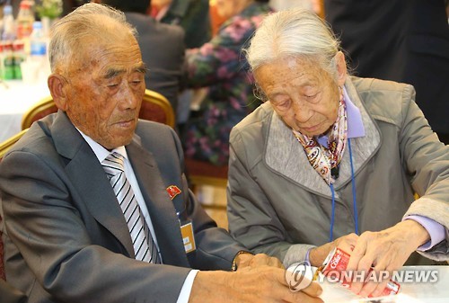 제20차 이산가족 상봉행사 1회차 둘째날인 21일 오전 금강산면회소에서 열린 단체상봉 행사에서 이순규(85) 할머니가 북측에서 남편 오인세(83) 할아버지에게 콜라를 따라주고 있다.