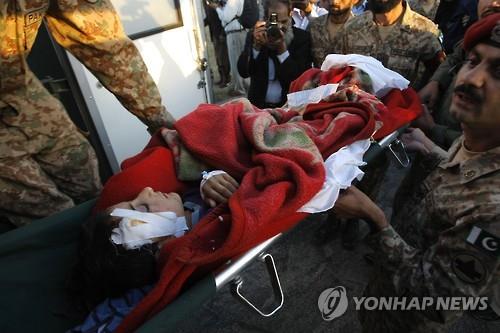 27일 파키스탄 페샤와르 군기지에서 군인들이 다친 소녀를 옮기고 있따.(AP=연합뉴스)