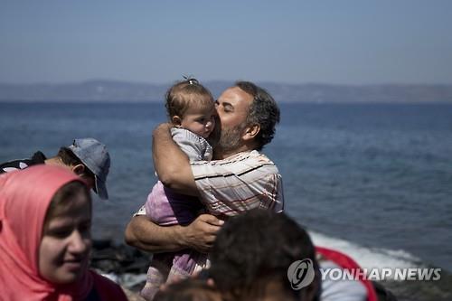 지난달 19일(현지시간) 터키에서 보트를 이용해 그리스 레스보스 섬에 도착한 한 시리아 난민이 딸에게 키스하고 있다. (AP=연합뉴스 자료사진)