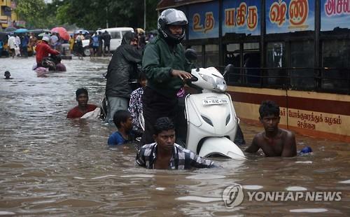 9일 인도 남부 타밀나두 주 첸나이에서 주민들이 물에 잠긴 도로를 이동하고 있다.(AFP=연합뉴스 자료사진)