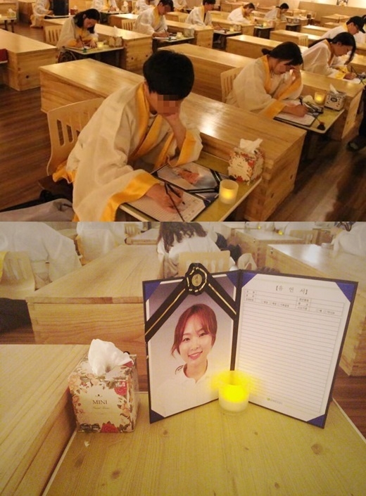 수의를 입고 자신의 영정사진을 보며 유언을 쓰는 참가자들. 수의를 입고 자신의 영정사진을 보며 유언을 쓰는 참가자들.