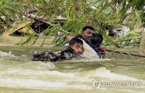 3일(현지시간) 인도 첸나이에서 군인들이 급류에 휘말린 한 남성을 구조하고 있다.(AP=연합뉴스)