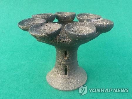 함안 말이산고분군서 출토된 희귀 등잔형 토기 (함안=연합뉴스) 세계문화유산 등재를 추진 중인 경남 함안 말이산고분군에서 출토된 희귀 등잔형 토기. 굽다리 상부에 있는 둥근 원통관 상부에 심지를 꽂을 수 있는 높이 2.1㎝, 직경 6.1㎝ 크기의 등잔 7개가 연결돼 눈길을 끈다. <함안군 제공>>