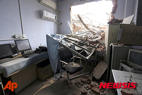 In this Thursday, Jan. 7, 2016 photo, rubble and debris spills into a room at the No. 4 Hospital of Zhengzhou University after a demolition crew destroyed part of the facility in Zhengzhou in central China's Henan province. Bulldozers unexpectedly demolished part of a hospital involved in a land dispute and its adjoining morgue in central China, sending doctors, nurses and patients fleeing and burying under rubble six bodies being processed at the morgue, reports said Friday. (Chinatopix via AP) CHINA OUT