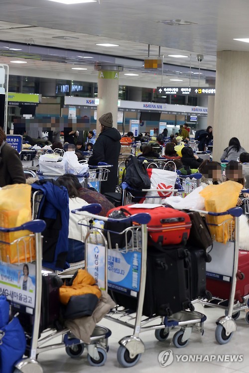 (제주=연합뉴스) 고성식 기자 = 24일 새벽 제주공항 내 항공사의 항공권 발권데스크 앞에서 항공편 운항이 재개되기를 바라는 많은 체류객이 쪽잠을 청하거나 이야기를 나누고 있다. 2016.1.24     koss@yna.co.kr