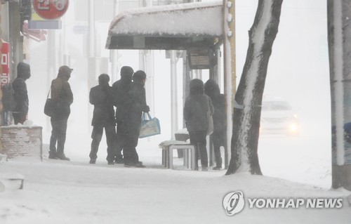 30여년만의 기록적인 폭설에 제주도 전 지역이 눈으로 뒤덮인 24일 제주시 이도동의 한 버스정류장에서 사람들이 버스를 기다리고 있다.