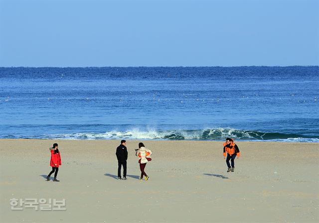 여행객들이 화진포 해변에서 겨울바람을 즐기고 있다