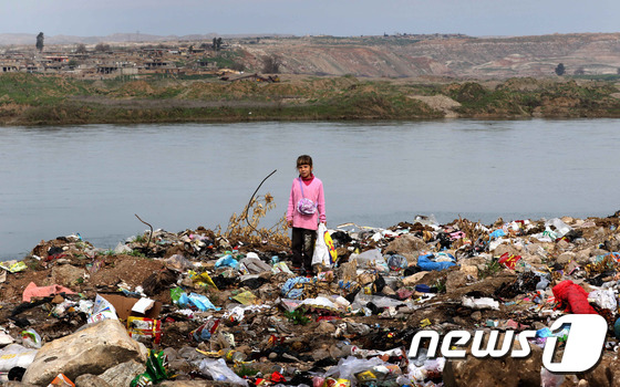 3일(현지시간) 와나시의 티크리스강 유역에서 한 어린아이가 쓰레기를 뒤지고 있다. 티크리스강 주변은 와나 주민들에게 삶의 터전이다. ©afp= News1