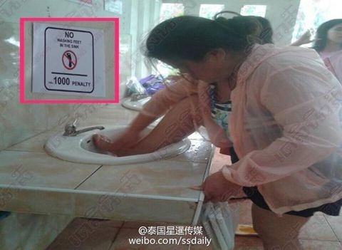 외국 공중화장실에서 발을 닦는 중국 여성의 모습