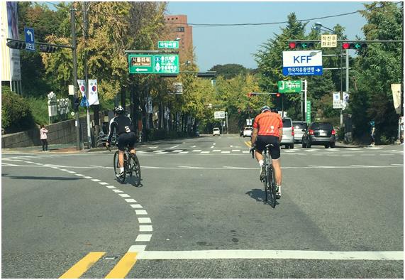 서울 중구 국립극장교차로에서 자전거 이용자들이 편도 3차로 중 1차로에서 좌회전하고 있다.