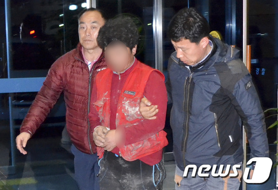 주차장에서 지인을 돌로 내리쳐 살해한 이모씨(48)가 지난 3월24일 오후 광주 서부경찰서에 살인 혐의로 긴급체포돼 압송되고 있는 모습. 2016.3.24/뉴스1 © News1 신채린 기자