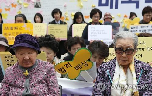 20일 오후 서울 종로구 주한일본대사관 앞에서 열린 '일본군 위안부 문제 해결을 위한 정기 수요시위'에 참석한 길원옥(왼쪽), 김복동 할머니가 일본과 에콰도르 지진 희생자들을 위해 묵념을 하고 있다.(연합뉴스)