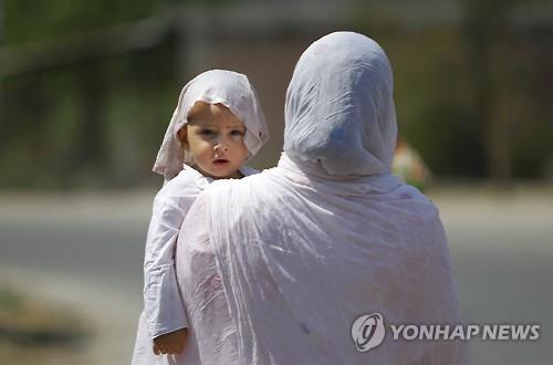 19일 인도 북부 잠무에서 모녀가 머리에 천을 덮고 서 있다.(AP=연합뉴스 자료사진)