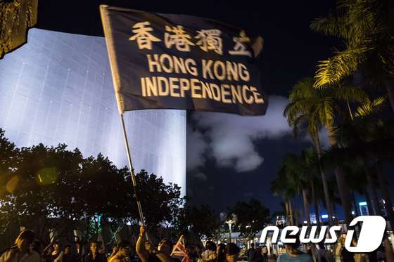 지난 4일 홍콩 참샤추이에서 열린 '천안문사태 27주년' 시위에서 한 참가자가 '홍콩 독립'이 적힌 깃발을 흔들고 있다. © AFP=뉴스1