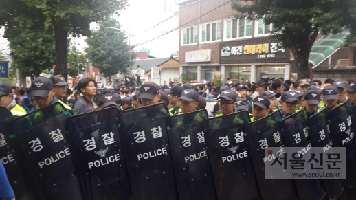 경찰들이 방패를 들고 황교안 국무총리가 탄 차를 보호하고 있다.