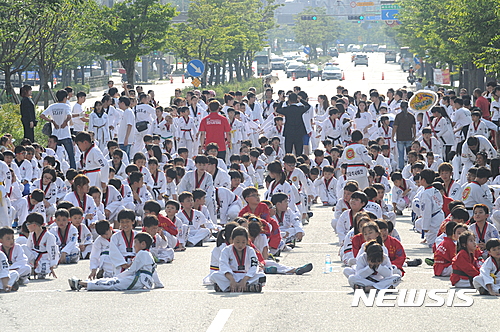 18일 전북도청 앞에서 무주태권도선수권대회 성공을 염원하는 행사가 열린 가운데 퍼포먼스에 참여한 초등학생들이 아스팔트 위에서 리허설을 하고 있다.