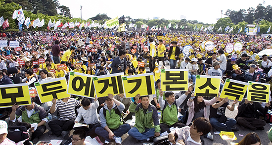 ⓒ기본소득한국네트워크 제공 : 2009년 노동절 대회 현장에서 참가자들이 “모두에게 기본소득을” 피켓을 들고 퍼포먼스를 하고 있다.