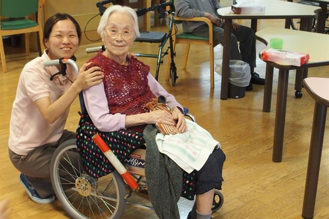 도쿄도 다이토구에 있는 구립특별노인요양원에서 간병전문직원인 고바야시 미호(왼쪽)씨가 올해 100살인 가네무라 유키코 할머니와 대화를 나누고 있다. 도쿄=박석원특파원