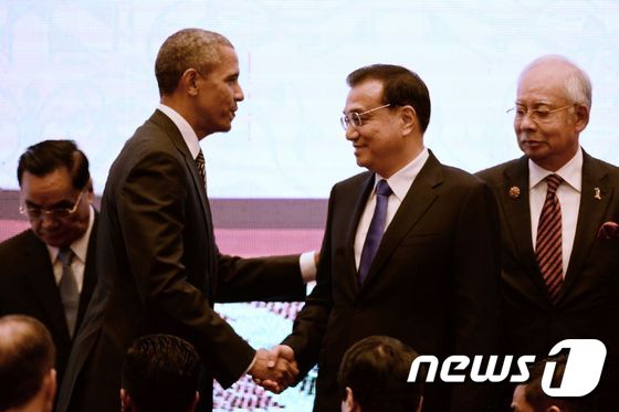 지난해 말레이시아 쿠알라룸푸르 컨벤션 센터에서 열린 10차 동아시아 정상회의(EAS)에서 버락 오바마 미국 대통령(좌측)과 리커창(李克强) 중국 총리가 만나 악수를 하고 있다.  © AFP=뉴스1 © News1