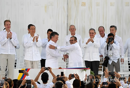 후안 마누엘 산토스 콜롬비아 대통령(가운데 왼쪽)과 콜롬비아 최대 반군 콜롬비아무장혁명군(FARC) 지도자 로드리고 론도뇨가 지난달 26일(현지시간) 해안도시 카르타헤나에서 52년간의 내전을 끝내는 역사적인 평화협정에 공식 서명한 후 악수를 하고 있다. [AFP=연합뉴스]