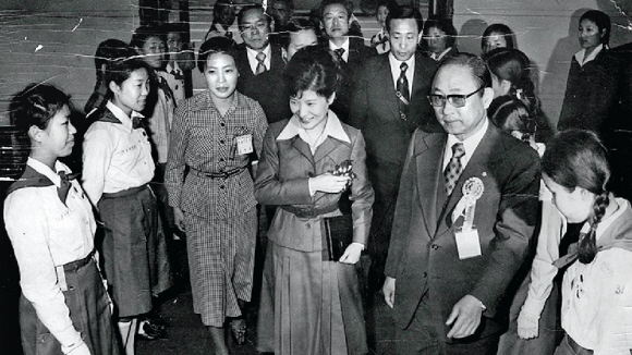 최태민 영생교 - 1977년 3월 당시 퍼스트레이디 자리를 대신하던 박근혜(왼쪽 네 번째) 대통령이 새마을궐기대회에 참석해 최태민씨의 안내를 받으며 걸스카우트 대원들에게 인사하고 있다.