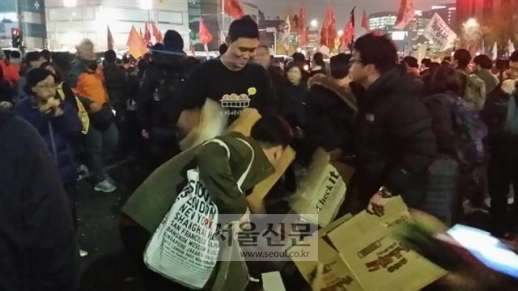 쓰레기를 줍고, 무료로 빵을 나누어 주는 손..촛불은 배려다 - 서울신문