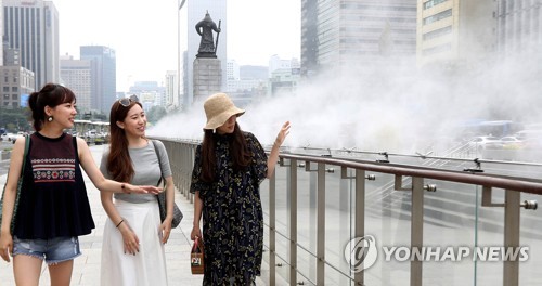(서울=연합뉴스) 최재구 기자 = 폭염이 계속된 20일 서울 광화문 광장에서 시민들이 물방울 분무 시설 옆을 지나며 더위를 식히고 있다. 이날 서울을 비롯한 수도권에는 폭염 특보가 내려졌다. jjaeck9@yna.co.kr