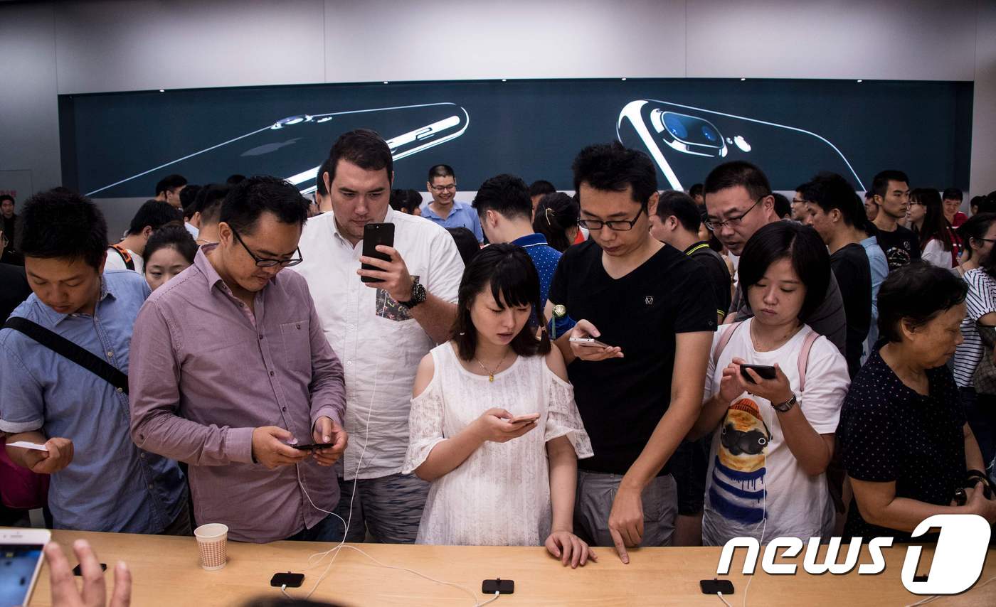 아이폰 7이 출시된 지난해 9월 상하이 애플 스토어에서 중국 소비자들이 아이폰을 만져보고 있다.  © AFP=뉴스1