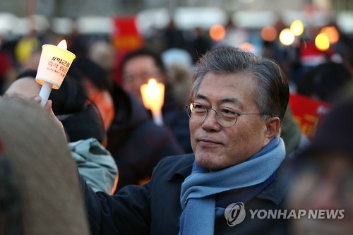 (서울=연합뉴스) 황광모 기자 = 더불어민주당 문재인 전 대표가 성탄을 하루 앞둔 24일 오후 서울 광화문광장에서 열린 제9차 촛불집회에서 촛불을 들고 구호를 외치고 있다.  2016.12.24   [문재인 전 대표 제공=연합뉴스]     hkmpooh@yna.co.kr