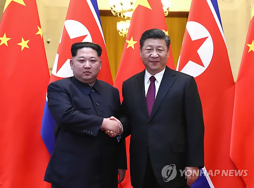 김정은과 시진핑 (베이징 신화=연합뉴스) 미국 언론들은 27일(현지시간) 북한 김정은의 중국 방문엔 도널드 트럼프 대통령과의 북미정상회담을 앞둔 북측의 여러 가지 노림수가 깔렸다는 분석을 내놨다.   북한의 가장 중요한 동맹이면서도 2011년 김 위원장 집권 이후 긴장이 고조돼온 중국과의 관계를 복원, 이를 지렛대로 대미 협상력을 높임으로써 판세를 유리한 국면으로 가져가는 동시에 제재완화 등을 얻어내고 협상 실패 시 미국이 꺼내 들 수 있는 군사옵션을 막는 등의 포석이 담겨 있다는 것이다. 사진은 김정은(왼쪽)이 이날 베이징의 인민대회당에서 중국 시진핑 국가주석과 만나 악수하는 모습.  bulls@yna.co.kr