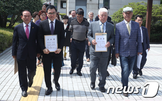 ì˜í™” 'íƒì‹œìš´ì „ì‚¬'ì˜ ì‹¤ì œ ì£¼ì¸ê³µ ê¹?ì‚¬ë³µì”¨ì˜ ì•„ë“¤ ê¹?ìŠ¹í•„ì”¨(ì•žì¤„ ì™¼ìª½ ë‘ë²ˆì§¸)ì™? ì§?ìš©ì”¨(ì•žì¤„ ì˜¤ë¥¸ìª½ ë‘ë²ˆì§¸)ê°? ì˜¬í•´ 6ì›”4ì¼ ì˜¤ì „ ê´‘ì£¼ì§?ê²?ì— ì§?ë§Œì›ì”¨ë¥¼ ì‚¬ìžëª…ì˜ˆí›¼ì† ë° ì •ë³´í†µì‹ ë§ë²•ìƒ ëª…ì˜ˆí›¼ì† í˜ì˜ë¡œ ê³ ì†Œí•˜ê¸°ìœ„í•´ ì´ë™í•˜ê³  ìžˆë‹¤./ì‚¬ì§„=ë‰´ìŠ¤1