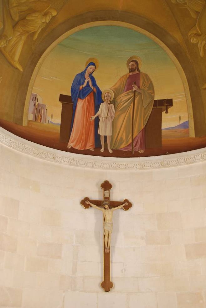 나사렛 성 요셉 교회의 제단 위에 걸린 십자가와 성 가족 그림.