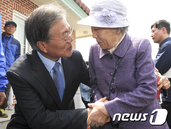 문재인 더불어민주당 전 대표가 제 20대 총선을 앞둔 마지막 주말인 9일 오전 김홍걸 국민통합위원장과 함께 광주 서구 서창 발산마을을 찾아 한 노인과 악수를 나누고 있다. 문 대표는 지난해 4·29 광주 서구을 보궐선거 전·후 이 마을회관을 3차례 방문했다. 2016.4.9/뉴스1 © News1 신채린 기자