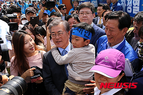 【정읍=뉴시스】김종효 기자 = 9일 오후 더불어민주당의 문재인 전 대표가 제20대 총선 전북 정읍·고창선거구에 출마한 하정열 후보의 지원유세차 정읍을 방문했다.   정읍에서는 문재인 전 대표의 방문에 2000여명의 인파가 몰려 문 전 대표를 환영했다.    문 전 대표가 자신의 이름이 적힌 두건 쓴 어린이를 안아 들며 시민들에게 인사하고 있다. 2016.04.09.   seun6685@newsis.com