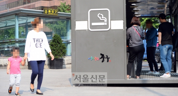 6일 서울 중구 을지로입구역 8번 출구 근처에 설치된 흡연실 옆을 한 시민이 아이와 함께 지나고 있다.박윤슬 기자 seul@seoul.co.kr