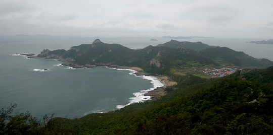 관매도의 돈대산 정상에서 내려다본 관호마을 쪽 해안의 풍경. 산 정상을 넘자마자 이런 풍경이 펼쳐진다. 바다 쪽으로 길게 뻗어 나간 지맥이 힘차다. 오른쪽으로 주황색 지붕의 집들이 모여있는 곳이 관호마을이다.