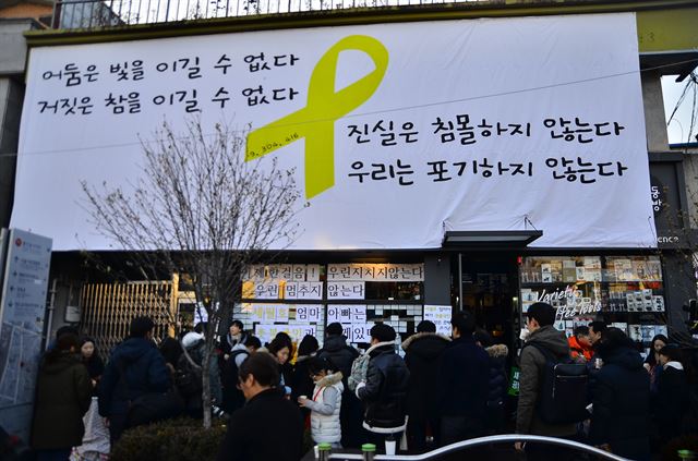 세월호 가족들이 통인동 커피공방 앞에서 촛불집회 참가자들에게 따뜻한 물과 핫팻을 나눠주고 있다.