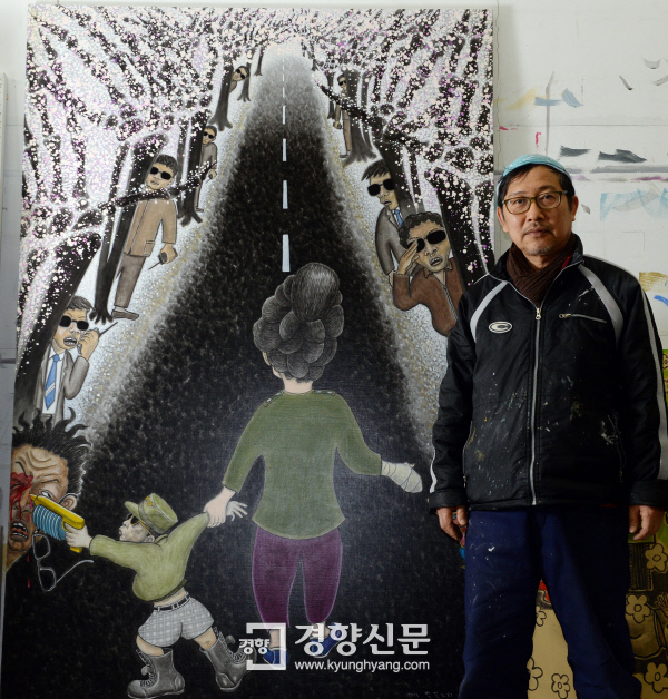 홍성담 작가가 ‘벚꽃노리’(2013년)를 배경으로 서 있다./ 강윤중 기자