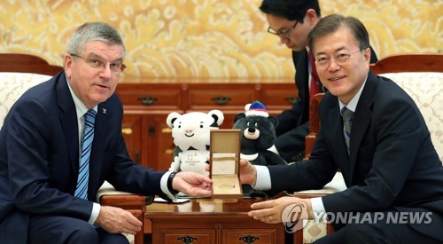 (서울=연합뉴스) 김주형 기자 = 문재인 대통령이 3일 오전 청와대 본관 접견실에서 토마스 바흐 국제올림픽위원회(IOC) 위원장으로부터 선물 받은 IOC 기념메달을 들어 보이고 있다. 2017.7.3      kjhpress@yna.co.kr