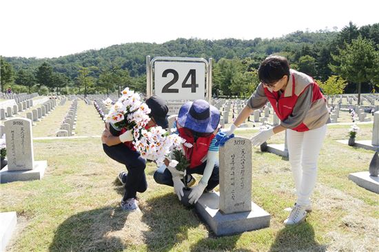 ▲ 롯데건설 임직원 봉사단이 서울 동작구에 위치한 국립현충원에서 묘역 단장을 하고 있다.