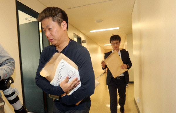 공론화위원회 관계자들이 지난 15일 충남 천안의 계성원에서 진행된 시민참여단 설문조사 결과지를 들고 취합 장소로 급히 이동하고 있다. 연합뉴스