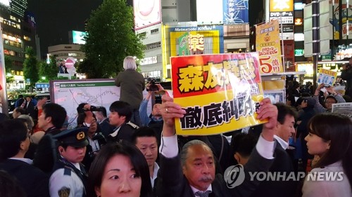 (도쿄=연합뉴스) 최이락 특파원 = 18일 오후 일본 도쿄 이케부쿠로(池袋)역 동쪽 출구 앞에서 열린 자민당 총재인 아베 신조(安倍晋三) 총리의 지원 유세 현장에서 시민들이 아베 총리와 부인 아키에(昭惠) 여사가 연루된 '사학스캔들'과 안보관련법 강행을 비판하는 패널을 들고 시위를 하고 있다. 2017.10.18 choinal@yna.co.kr