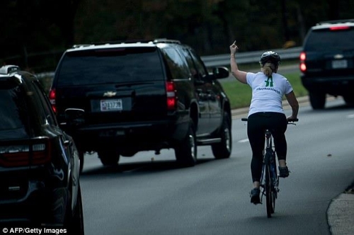28일(현지시간) 오후 버지니아주 스털링에 있는 트럼프 내셔널 골프클럽 부근 도로에서 도널드 트럼프 미국 대통령의 차량 행렬이 지나가자 자전거를 타고 가던 한 여성이 손가락 욕설을 하는 모습 [게티이미지]