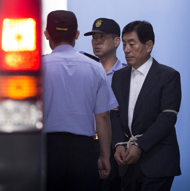 수갑을 차고 호송차에 오르고 있는 전 국가정보기관의 수장. /조선DB